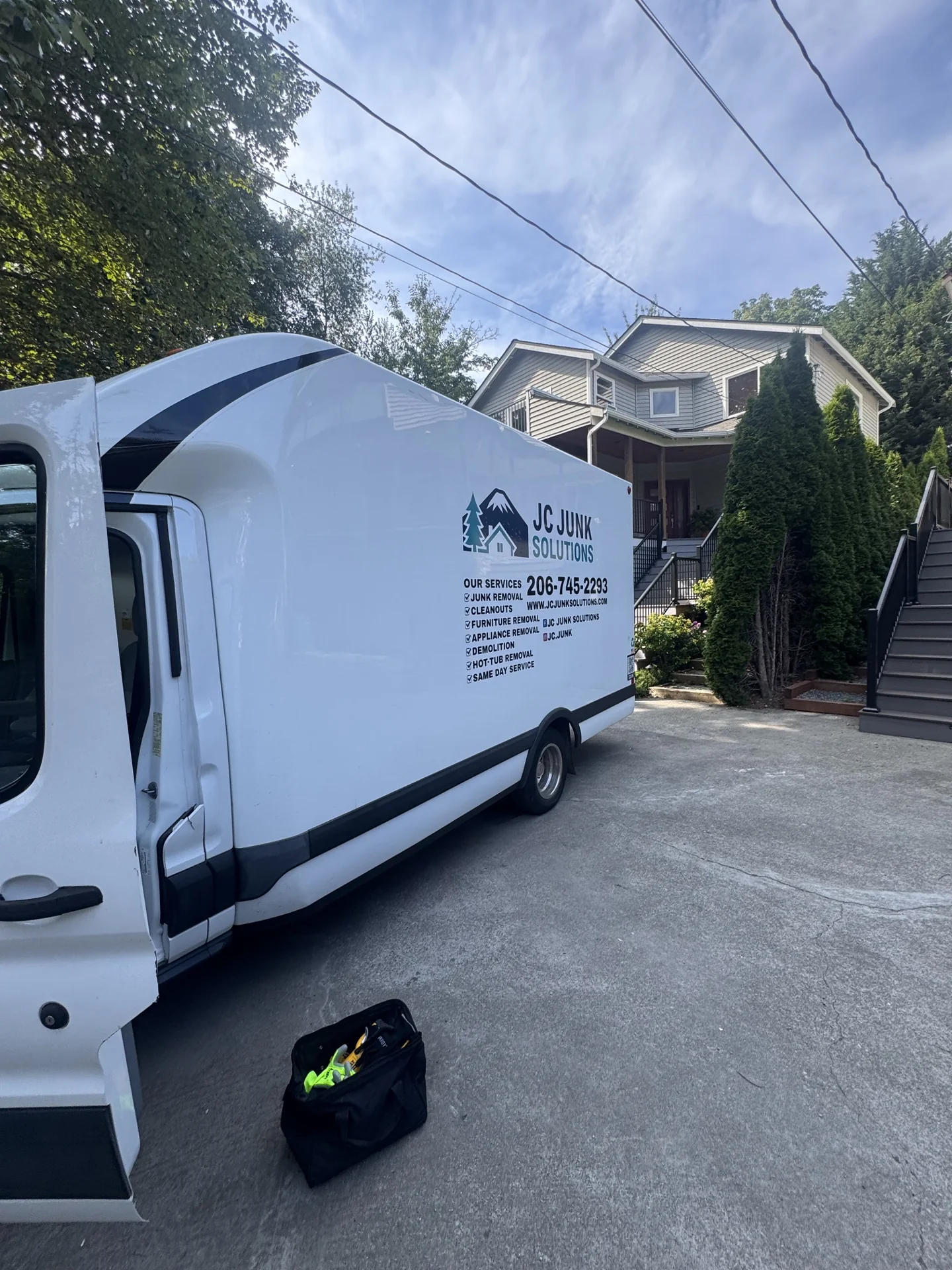 JC Junk Solutions box truck parked at a residential pickup