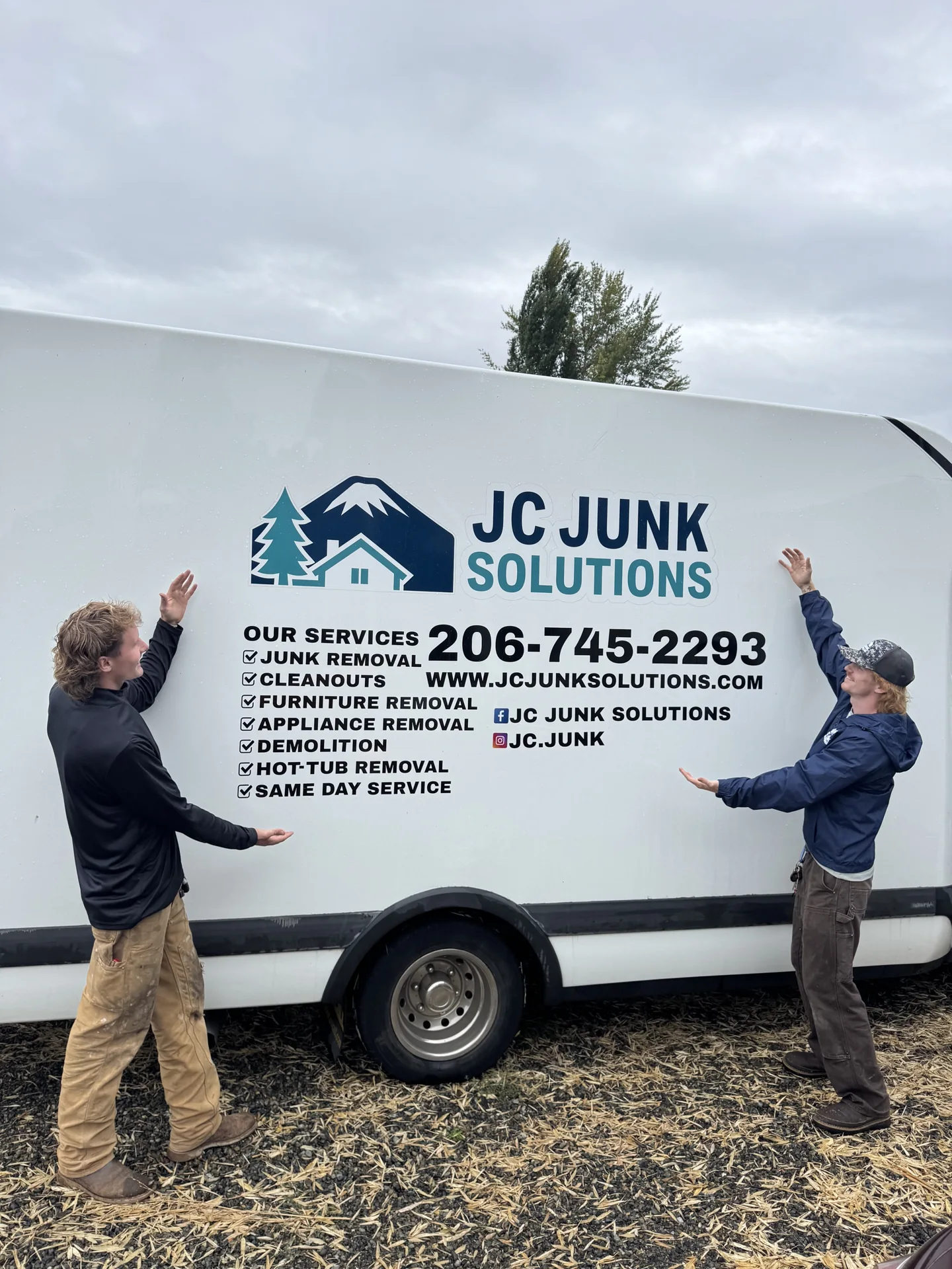Two JC Junk Solutions crew members beside their branded box truck