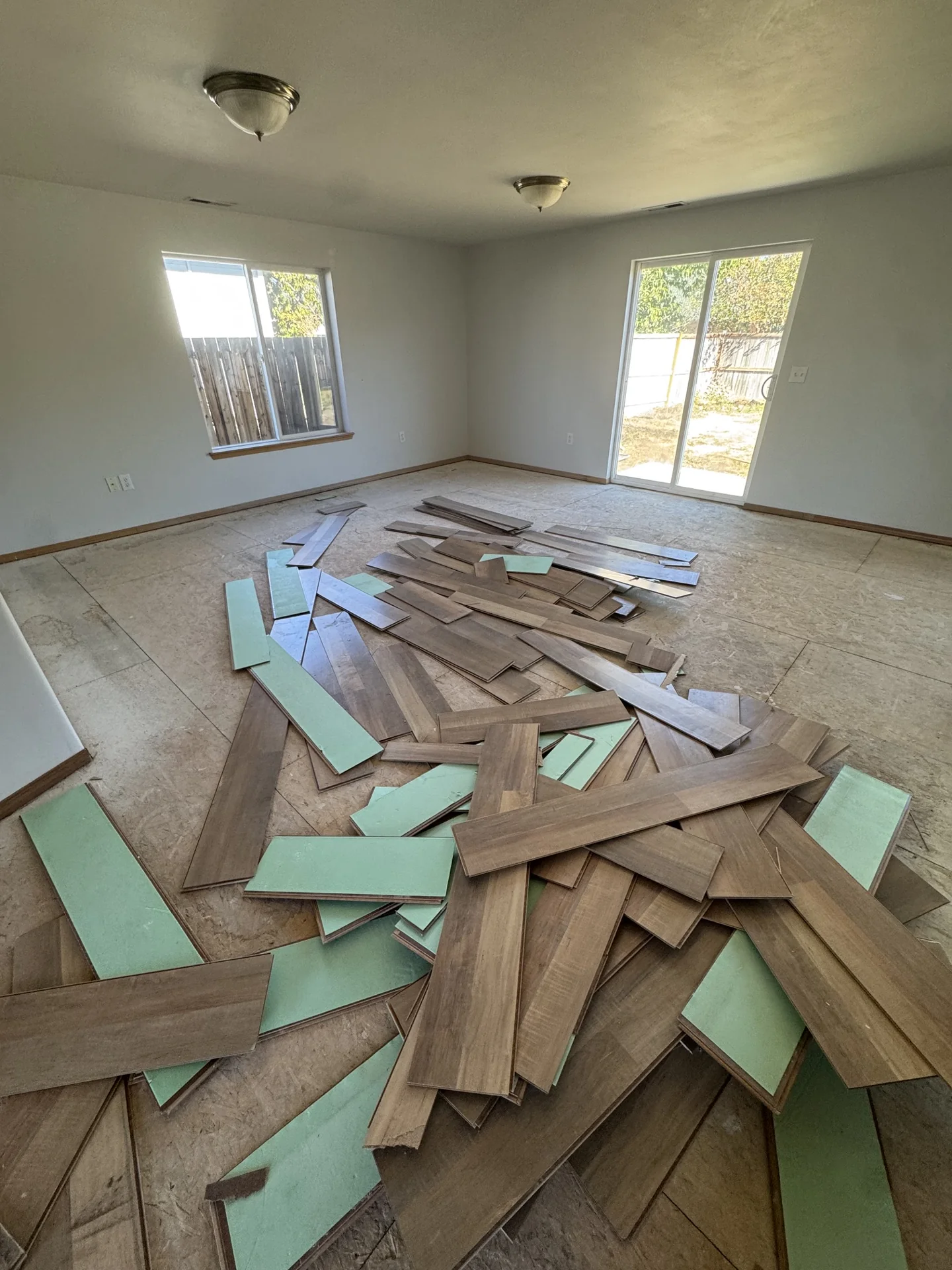 Removed flooring boards and underlayment gathered inside a room